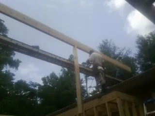 Carpenter setting a ridge beam over a new addition frame — Ice Dam Removal by Roofing Brothers in Collegedale