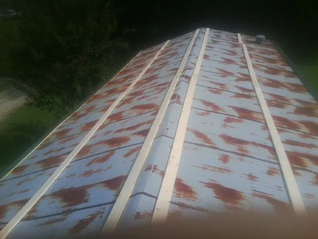 Rusted metal roof panels with new wood purlins before replacement — Storm Damage Roof Repair in Collegedale by Roofing Brothers