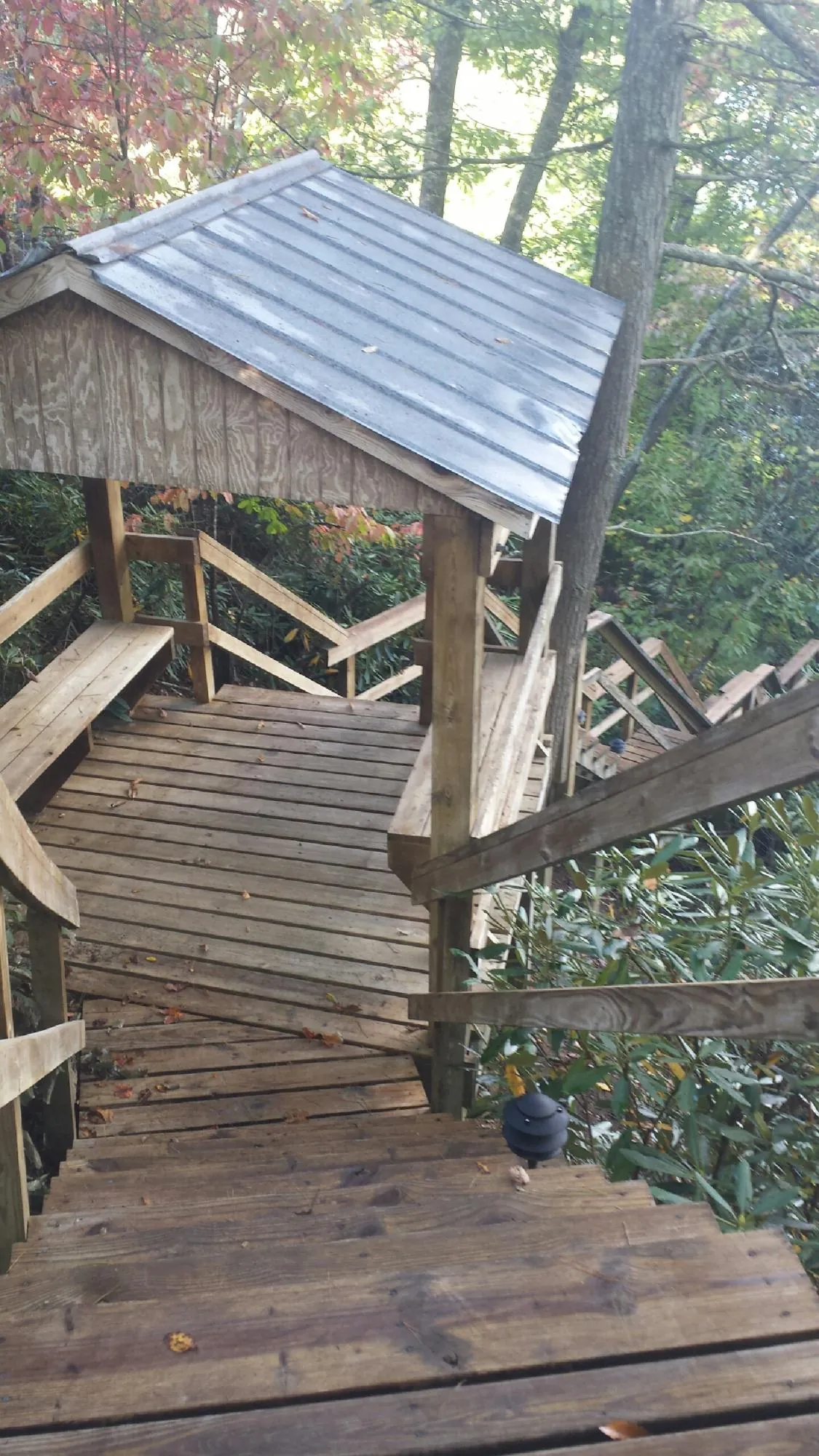 Metal roofed shelter over wooden steps on a wooded walkway — Skylight Repair & Installation work by our crew in Collegedale