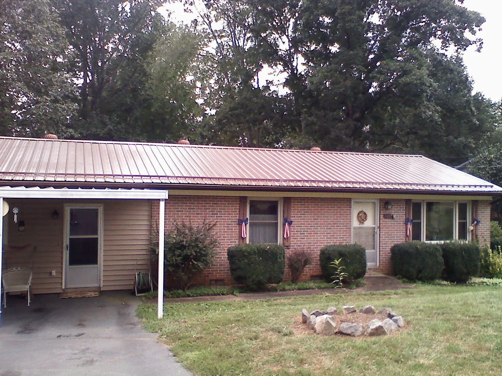 Bronze metal roof and carport on a brick ranch home — Roof Repair work by our crew in Collegedale